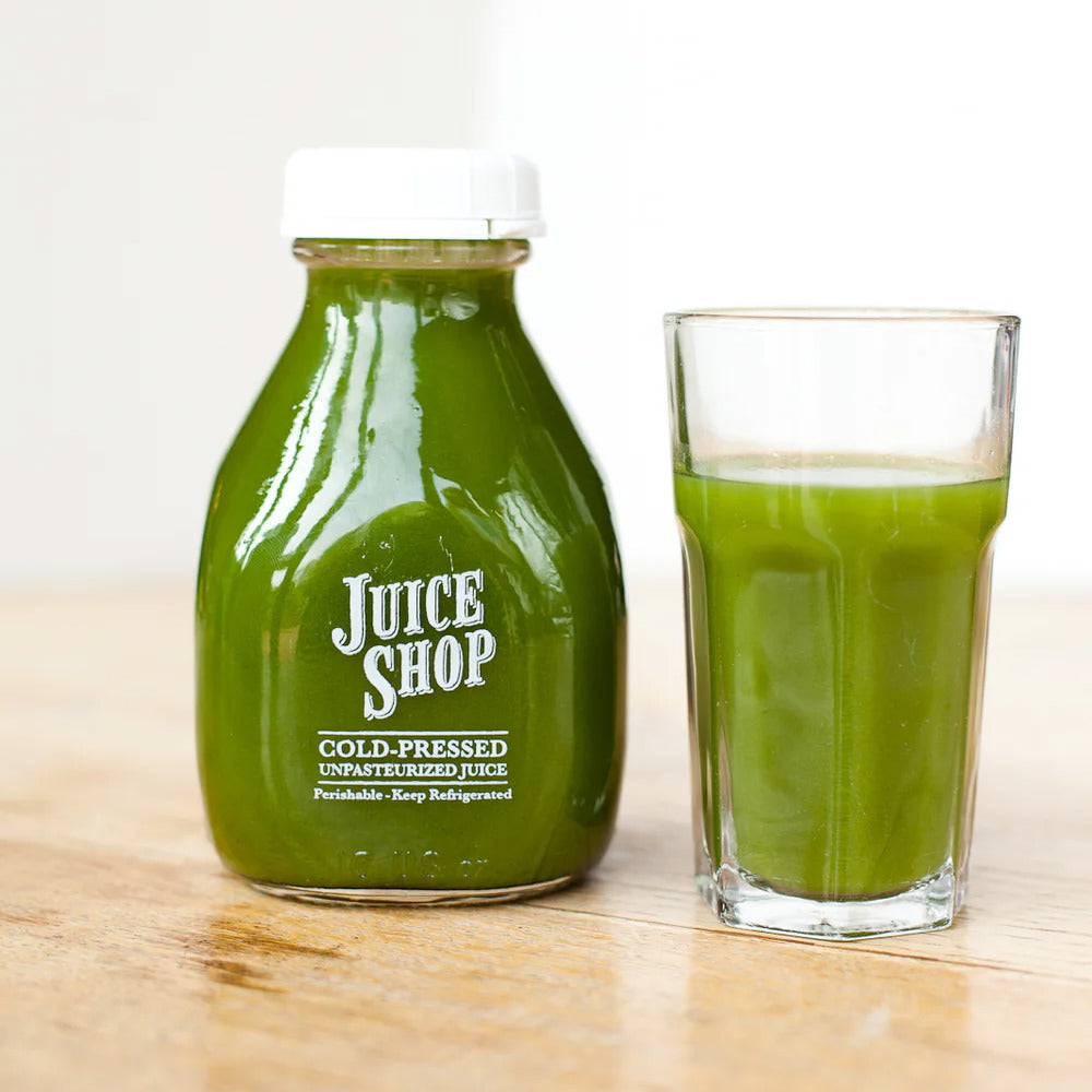 Juice Shop cold-pressed green juice in glass bottle and cup.