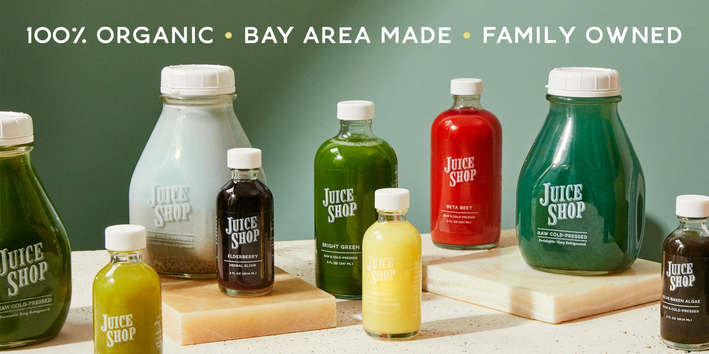 Lineup of Juice Shop cold-pressed juice bottles in various colors and sizes