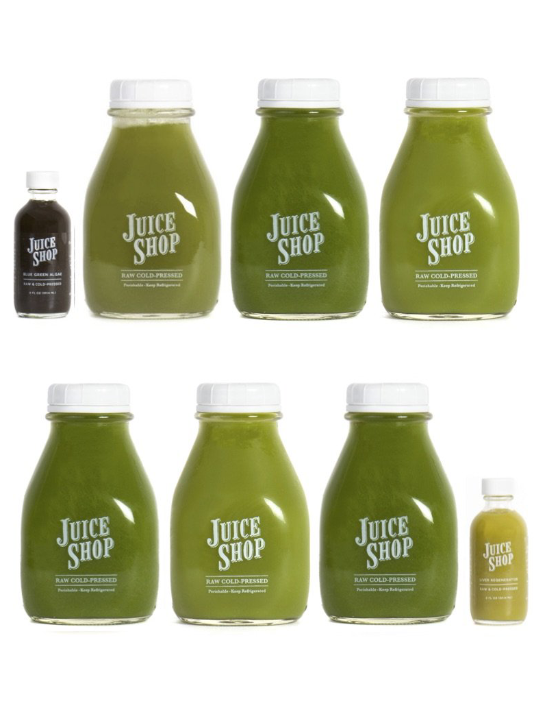 Assorted Juice Shop green juices and shots in glass bottles with white caps.