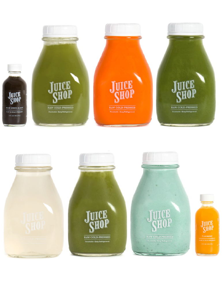 Assorted Juice Shop raw cold-pressed juices in glass bottles with white caps, featuring vibrant colors.